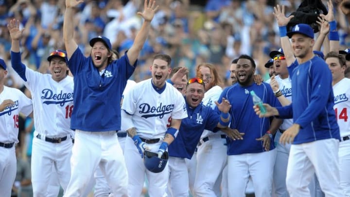 September 25, 2016; Los Angeles, CA, USA; Los Angeles Dodgers starting pitcher Kenta Maeda (18), starting pitcher Clayton Kershaw (22), catcher Yasmani Grandal (9) and catcher Carlos Ruiz (51) celebrate after shortstop Charlie Culberson (6) hits a walk off solo home run in the tenth inning against the Colorado Rockies at Dodger Stadium. With the victory the Dodgers clinch the National League West title. Mandatory Credit: Gary A. Vasquez-USA TODAY Sports