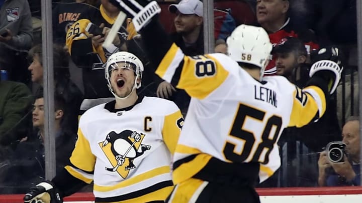 NEWARK, NJ - MARCH 29: Sidney Crosby #87 of the Pittsburgh Penguins celebrates his game winning goal in overtime and is joined by Kris Letang #58 against the New Jersey Devils at the Prudential Center on March 29, 2018 in Newark, New Jersey. The Penguins defeated the Devils 4-3 in overtime. (Photo by Bruce Bennett/Getty Images)
