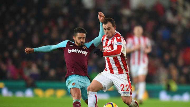 STOKE ON TRENT, ENGLAND - DECEMBER 16: Xherdan Shaqiri of Stoke City is tackled by Manuel Lanzini of West Ham United during the Premier League match between Stoke City and West Ham United at Bet365 Stadium on December 16, 2017 in Stoke on Trent, England. (Photo by Tony Marshall/Getty Images)
