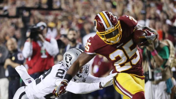 LANDOVER, MD - SEPTEMBER 24: Running back Chris Thompson #25 of the Washington Redskins scores a touchdown as cornerback Chris Thompson #22 of the Oakland Raiders tries to stop him in the first quarter at FedExField on September 24, 2017 in Landover, Maryland. (Photo by Patrick Smith/Getty Images)