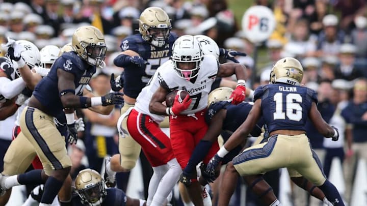 Cincinnati Bearcats Tre Tucker pushes through Navy's defense during the second half. The Enquirer.