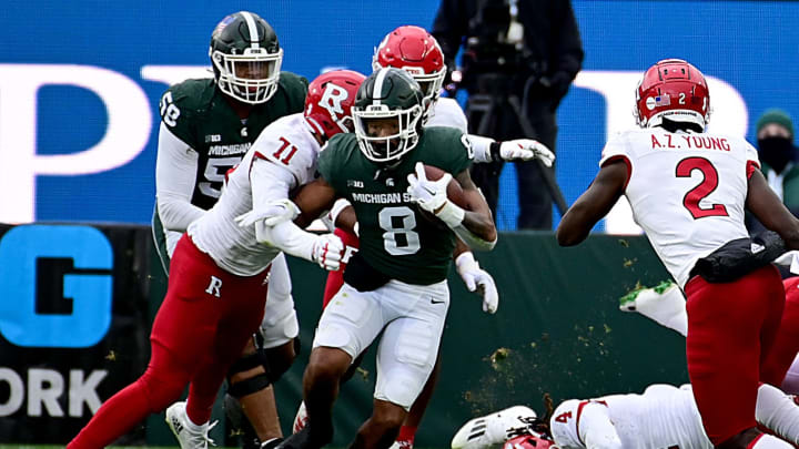 Nov 12, 2022; East Lansing, Michigan, USA; Michigan State Spartans running back Jalen Berger (8) dodges a tackle by Rutgers Scarlet Knights defensive lineman Aaron Lewis (71) at Spartan Stadium. Mandatory Credit: Dale Young-USA TODAY Sports