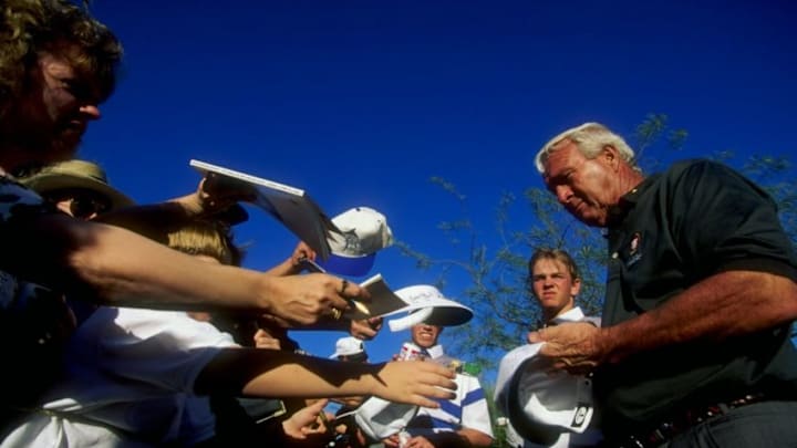 20 Jan 1996: Golfer Arnold Palmer autographs a hat for a young fan during the Bob Hope Chrysler Classic in Palm Desert, California. Mandatory Credit: J.D. Cuban /Allsport