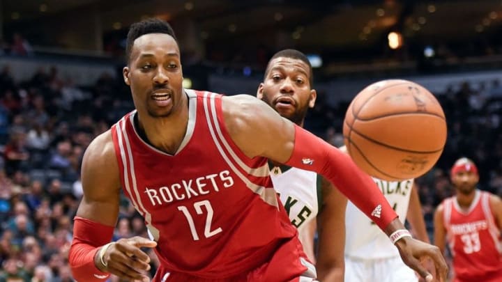 Feb 29, 2016; Milwaukee, WI, USA; Houston Rockets center Dwight Howard (12) and Milwaukee Bucks center Greg Monroe (15) reach for a loose ball in the first quarter at BMO Harris Bradley Center. Mandatory Credit: Benny Sieu-USA TODAY Sports