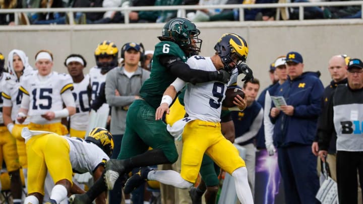Michigan quarterback J.J. McCarthy (9) is pushed out of bound by Michigan State linebacker Quavaris Crouch (6) during the second half at Spartan Stadium in East Lansing on Saturday, Oct. 30, 2021.