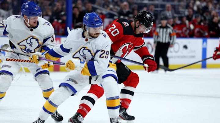 Nov 25, 2022; Buffalo, New York, USA; Buffalo Sabres center Vinnie Hinostroza (29) and New Jersey Devils center Michael McLeod (20) go after a loose puck during the first period at KeyBank Center. Mandatory Credit: Timothy T. Ludwig-USA TODAY Sports