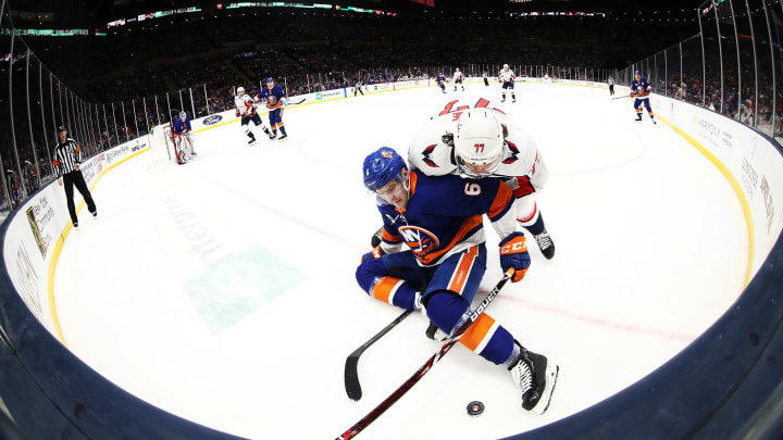 UNIONDALE, NEW YORK – MARCH 01: Ryan Pulock #6 of the New York Islanders and T.J. Oshie #77 of the Washington Capitals battle for the puck during their game at NYCB Live’s Nassau Coliseum on March 01, 2019 in Uniondale, New York. (Photo by Al Bello/Getty Images) NHL DFS