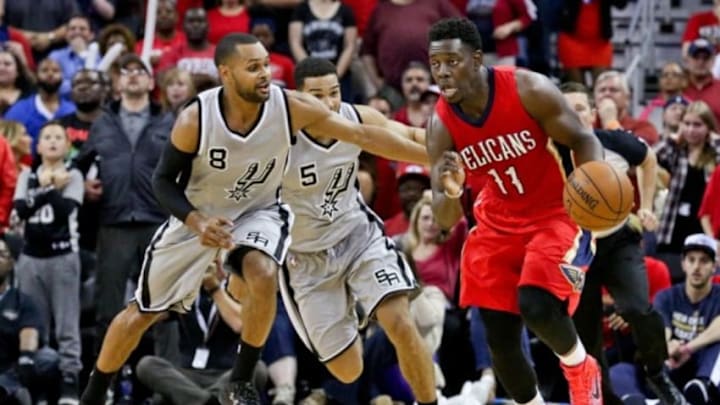 Apr 15, 2015; New Orleans, LA, USA; New Orleans Pelicans guard Jrue Holiday (11) drives past San Antonio Spurs guard Patty Mills (8) during a game at the Smoothie King Center. The Pelicans defeated the Spurs 108-103 and earned the 8th seed in the Western Conference Playoffs. Mandatory Credit: Derick E. Hingle-USA TODAY Sports