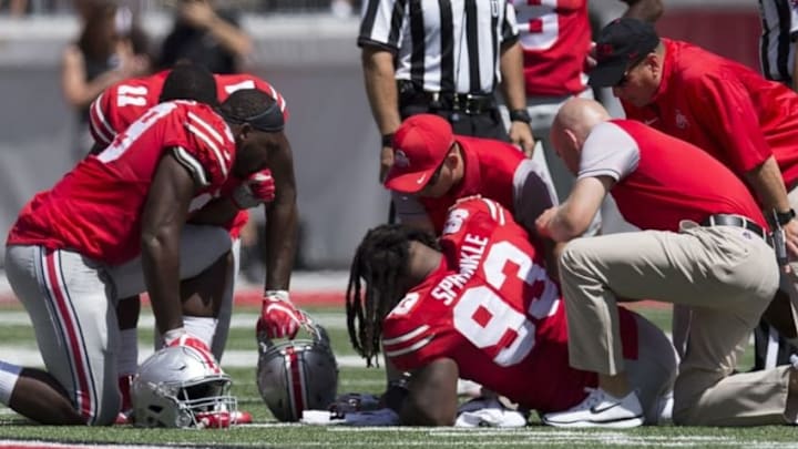 Sep 3, 2016; Columbus, OH, USA; Ohio State Buckeyes defensive lineman Tyquan Lewis (59) and defensive end Jalyn Holmes watch as (11) defensive lineman Tracy Sprinkle (93) is tended to after being injured against the Bowling Green Falcons at Ohio Stadium. Ohio State won the game 77-10. Mandatory Credit: Greg Bartram-USA TODAY Sports
