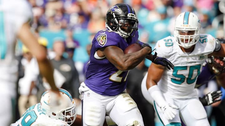 Dec 6, 2015; Miami Gardens, FL, USA; Baltimore Ravens running back Terrance West (27) carries the ball as Miami Dolphins defensive end Derrick Shelby (79) makes the tackle during the first half at Sun Life Stadium. Mandatory Credit: Steve Mitchell-USA TODAY Sports