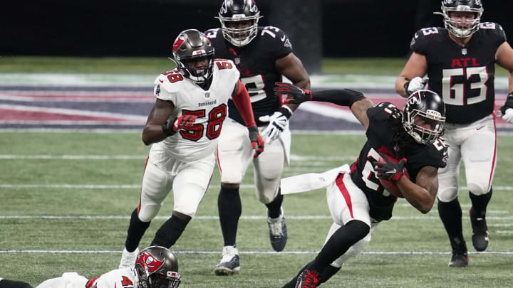 Dec 20, 2020; Atlanta, Georgia, USA; Atlanta Falcons running back Todd Gurley (21) runs away from Tampa Bay Buccaneers inside linebacker Devin White (45) in the first half of a NFL game at Mercedes-Benz Stadium. Mandatory Credit: Dale Zanine-USA TODAY Sports