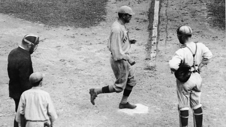 American baseball player Harry Hooper (1887 – 1974), in a Boston Red Sox uniform, steps on home plate after hitting the winning run in the 1915 World Series, Philadelphia, Pennsylvania, October 13, 1915. Bill Killefer (1887 – 1960), catcher for the Philadelphia Phillies, watches with his hands on his hips. Boston defeated Philadelphia four games to one. (Photo by Bruce Bennett Studios/Getty Images)