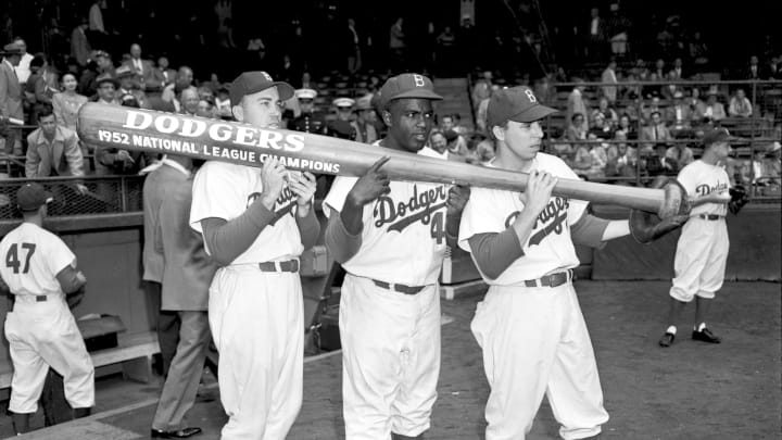 BROOKLYN, NY – OCTOBER 1952: (l to r) Outfielder Duke Snider #4, infielders Jackie Robinson #42 and Pee Wee Reese #1 of the Brooklyn Dodgers hold up an oversized bat which states the Dodgers are National League Champions for the 1952 season prior to a World Series game against the New York Yankees at Ebbets Field in Brooklyn, New York. (Olen Collection/Diamond Images/Getty Images)