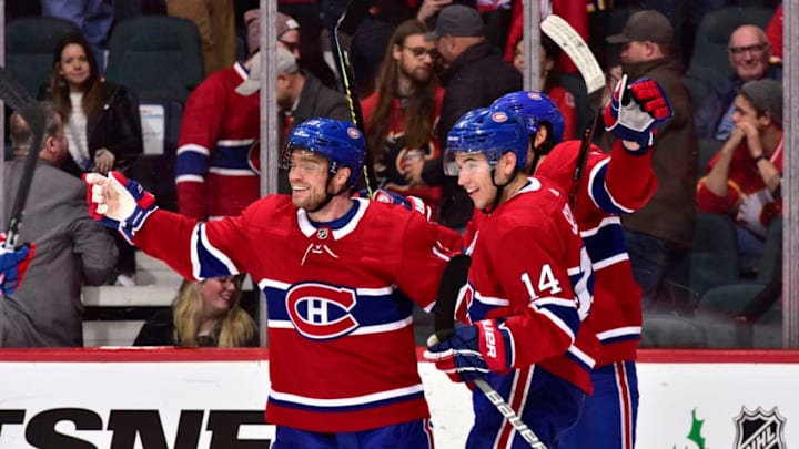 CALGARY, ALBERTA - DECEMBER 19: Max Domi #13, Nick Suzuki #14 and teammates of the Montreal Canadiens celebrate an overtime goal against the Calgary Flames at Scotiabank Saddledome on December 19, 2019 in Calgary, Canada. (Photo by Terence Leung/NHLI)