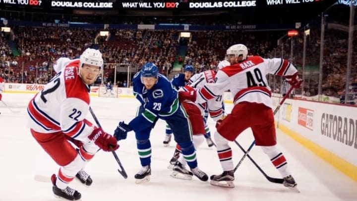 Oct 16, 2016; Vancouver, British Columbia, CAN; Vancouver Canucks defenseman Alexander Edler (23) and Carolina Hurricanes defenseman Brett Pesce (22) skate into the corner to retrieve the puck during the first period at Rogers Arena. The Vancouver Canucks won 4-3 in overtime. Mandatory Credit: Anne-Marie Sorvin-USA TODAY Sports