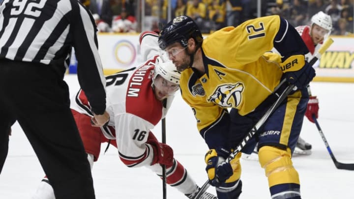 NASHVILLE, TN - OCTOBER 8: Mike Fisher #12 of the Nashville Predators and Elias Lindholm #16 of the Carolina Hurricanes await the drop of the puck by linesman Mark Shewchyk #92 at Bridgestone Arena on October 8, 2015 in Nashville, Tennessee. (Photo by Sanford Myers/Getty Images)