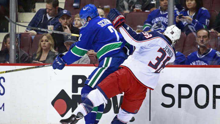 VANCOUVER, BC – MARCH 24: Luke Schenn #2 of the Vancouver Canucks checks Boone Jenner #38 of the Columbus Blue Jackets during their NHL game at Rogers Arena March 24, 2019 in Vancouver, British Columbia, Canada. (Photo by Jeff Vinnick/NHLI via Getty Images)