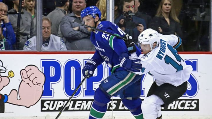 VANCOUVER, BC - APRIL 2: Gustav Nyquist #14 of the San Jose Sharks checks Alexander Edler #23 of the Vancouver Canucks during their NHL game at Rogers Arena April 2, 2019 in Vancouver, British Columbia, Canada. Vancouver won 4-2. (Photo by Jeff Vinnick/NHLI via Getty Images)