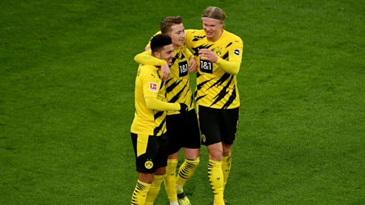 (L-R) Dortmund's English midfielder Jadon Sancho celebrates his 2-1 lead with his team mates Dortmund's German forward Marco Reus and Dortmund's Norwegian forward Erling Braut Haaland during the German first division Bundesliga football match BVB Borussia Dortmund v FC Augsburg in Dortmund, western Germany, on January 30, 2021. (Photo by Sascha STEINBACH / EPA POOL / AFP) / DFL REGULATIONS PROHIBIT ANY USE OF PHOTOGRAPHS AS IMAGE SEQUENCES AND/OR QUASI-VIDEO (Photo by SASCHA STEINBACH/EPA POOL/AFP via Getty Images)