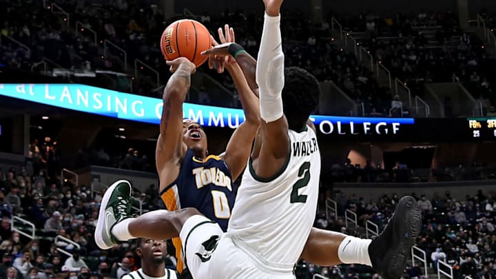 Dec 4, 2021; East Lansing, Michigan, USA; Toledo Rockets guard Ryan Rollins (5) and Michigan State Spartans guard Tyson Walker (2) fight over a shot under the basket at Jack Breslin Student Events Center. Mandatory Credit: Dale Young-USA TODAY Sports