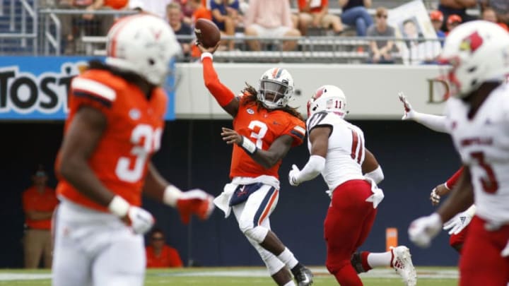 CHARLOTTESVILLE, VA - SEPTEMBER 22: Bryce Perkins #3 of the Virginia Cavaliers throws a pass under pressure from Dee Smith #11 of the Louisville Cardinals in the first half during a game at Scott Stadium on September 22, 2018 in Charlottesville, Virginia. (Photo by Ryan M. Kelly/Getty Images)