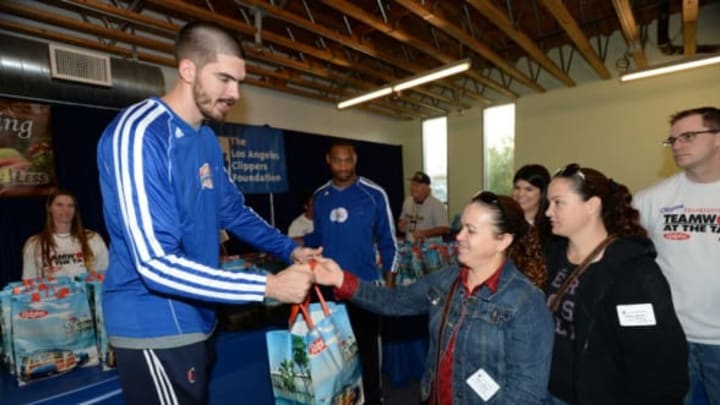 VENICE, CA – NOVEMBER 26: Byron Mullens of the Los Angeles Clippers hands out a Thanksgiving dinner during the Teamwork at the Table Thanksgiving Event at the St. Joseph Center on November 26, 2013 in Venice, California. NOTE TO USER: User expressly acknowledges and agrees that, by downloading and/or using this Photograph, user is consenting to the terms and conditions of the Getty Images License Agreement. Mandatory Copyright Notice: (Photo by Andrew D.Bernstein/NBAE via Getty Images)