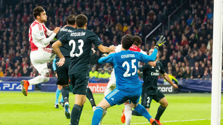 Real Madrid players scramble with Ajax forward Tadic in their Champions League clash