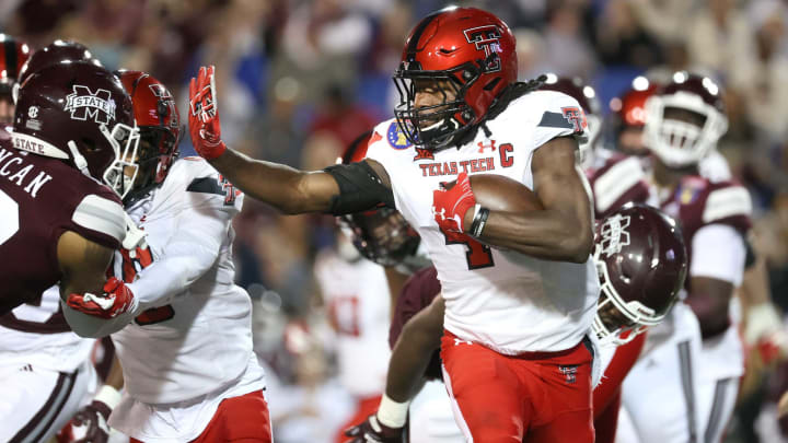 Texas Tech Red Raiders running back SaRodorick Thompson stiff arms his way out of the backfield against the Mississippi State Bulldogs at the AutoZone Liberty Bowl at Liberty Bowl Memorial Stadium on Tuesday, Dec. 28, 2021.Jrca6153