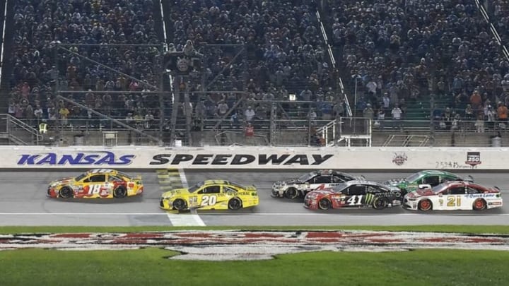 May 7, 2016; Kansas City, KS, USA; NASCAR Sprint Cup Series drivers Kyle Busch (18) and Matt Kenseth (20) lead the field to restart during the GoBowling.com 400 at Kansas Speedway. Mandatory Credit: Jasen Vinlove-USA TODAY Sports