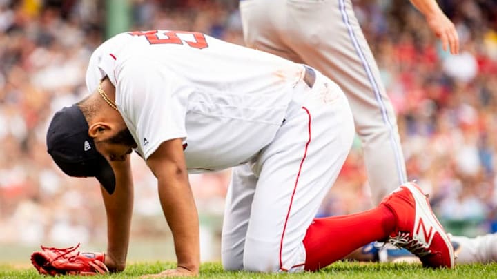 BOSTON, MA - JULY 14: Eduardo Rodriguez #57 of the Boston Red Sox reacts after colliding with Lourdes Gurriel Jr. after covering first base and recording the out during the sixth inning of a game against the Toronto Blue Jays on July 14, 2018 at Fenway Park in Boston, Massachusetts. (Photo by Billie Weiss/Boston Red Sox/Getty Images)