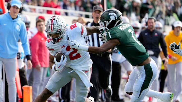 Oct 8, 2022; East Lansing, Michigan, USA; Ohio State Buckeyes wide receiver Emeka Egbuka (2) gets tackled by Michigan State Spartans safety Jaden Mangham (1) after a catch in the first quarter of the NCAA Division I football game between the Ohio State Buckeyes and Michigan State Spartans at Spartan Stadium.Osu22msu Kwr 21 Oct 8, 2022; East Lansing, Michigan, USA; Ohio State Buckeyes wide receiver Emeka Egbuka (2) gets tackled by Michigan State Spartans safety Jaden Mangham (1) after a catch in the first quarter of the NCAA Division I football game between the Ohio State Buckeyes and Michigan State Spartans at Spartan Stadium.Osu22msu Kwr 21