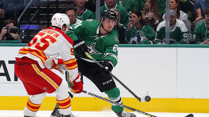 DALLAS, TEXAS – MAY 07: Noah Hanifin #55 of the Calgary Flames and Roope Hintz #24 of the Dallas Stars battle for the puck in Game Three of the First Round of the 2022 Stanley Cup Playoffs at American Airlines Center on May 07, 2022 in Dallas, Texas. (Photo by Richard Rodriguez/Getty Images)