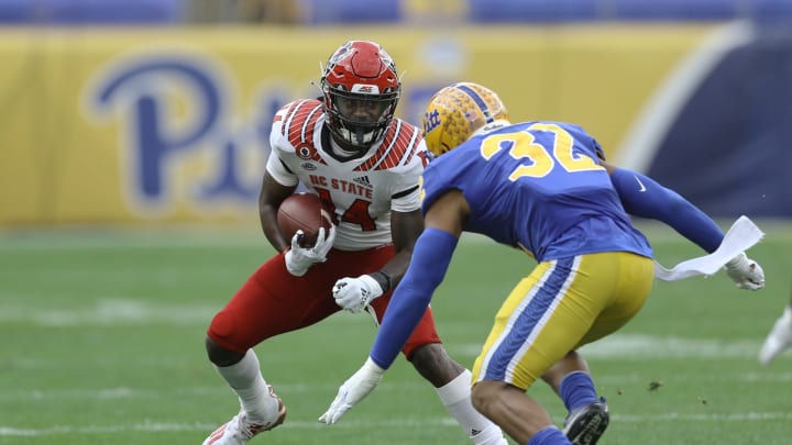 Oct 3, 2020; Pittsburgh, Pennsylvania, USA; North Carolina State Wolfpack wide receiver Porter Rooks (14) runs after a catch against Pittsburgh Panthers linebacker SirVocea Dennis (32) during the second quarter at Heinz Field. Mandatory Credit: Charles LeClaire-USA TODAY Sports
