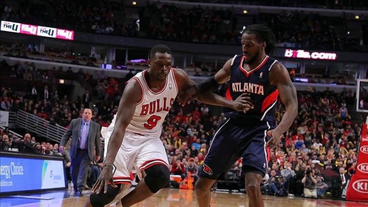 Jan 4, 2014; Chicago, IL, USA; Chicago Bulls small forward Luol Deng (9) drives against Atlanta Hawks small forward DeMarre Carroll (5) during the second half at the United Center. Chicago won 91-84. Mandatory Credit: Dennis Wierzbicki-USA TODAY Sports