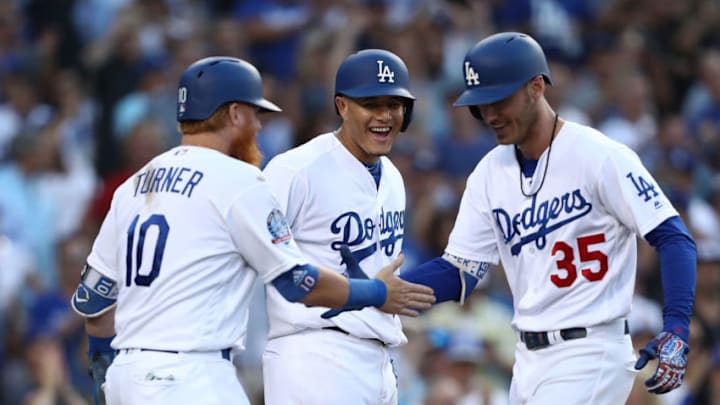 LOS ANGELES, CA - AUGUST 02: (L-R) Justin Turner #10, Manny Machado #8 and Cody Bellinger #35 of the Los Angeles Dodgers celebrate at home plate after Bellinger hit a grand slam homerun during the third inning of the MLB game against the Milwaukee Brewers at Dodger Stadium on August 2, 2018 in Los Angeles, California. (Photo by Victor Decolongon/Getty Images)