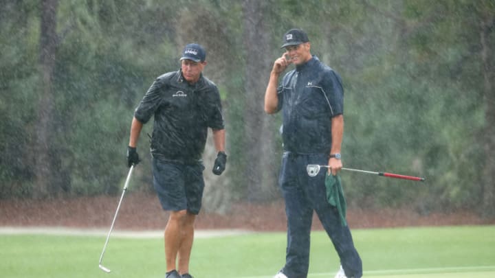 HOBE SOUND, FLORIDA - MAY 24: Phil Mickelson and NFL player Tom Brady of the Tampa Bay Buccaneers stand in the rain on the 13th green during The Match: Champions For Charity at Medalist Golf Club on May 24, 2020 in Hobe Sound, Florida. (Photo by Mike Ehrmann/Getty Images for The Match)
