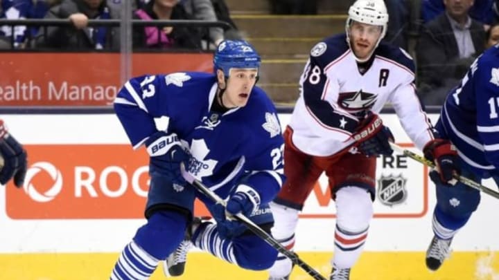 Jan 13, 2016; Toronto, Ontario, CAN; Toronto Maple Leafs center Shawn Matthias (23) skates the puck past Columbus Blue Jackets center Boone Jenner (38) during the Blue Jackets 3-1 win at Air Canada Centre. Mandatory Credit: Dan Hamilton-USA TODAY Sports