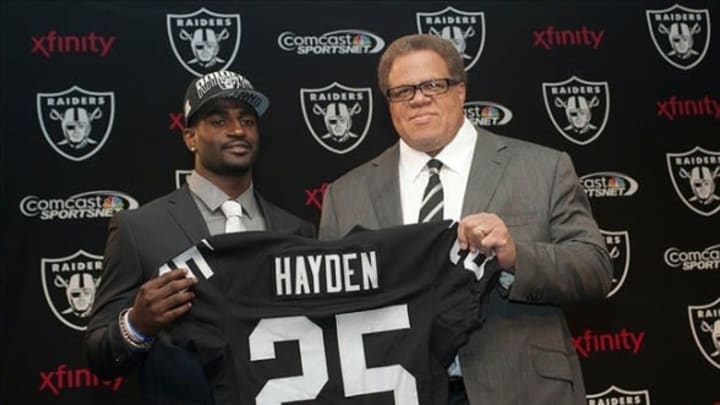 Apr 26, 2013; Alameda, CA, USA; Oakland Raiders first round selection D.J. Hayden and general manager Reggie McKenzie hold up a jersey at the press conference at Oakland Raiders headquarters. Mandatory Credit: Ed Szczepanski-USA TODAY Sports