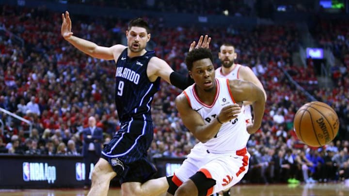 Kyle Lowry #7 of the Toronto Raptors dribbles the ball as Nikola Vucevic #9 of the Orlando Magic defends during Game Two of the first round of the 2019 NBA Playoffs at Scotiabank Arena. (Photo by Vaughn Ridley/Getty Images)