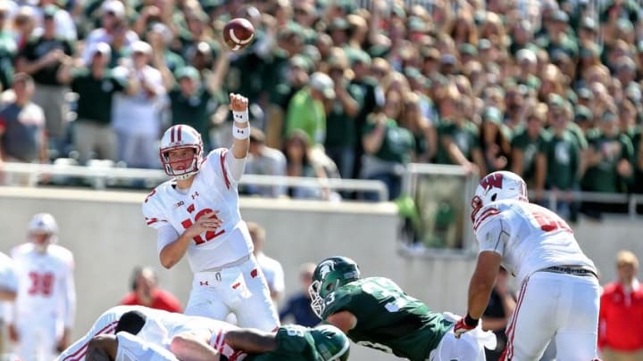 Sep 24, 2016; East Lansing, MI, USA; Wisconsin Badgers quarterback Alex Hornibrook (12) throws while pressured by Michigan State Spartans linebacker Jon Reschke (33) during the first half of a game at Spartan Stadium. Mandatory Credit: Mike Carter-USA TODAY Sports