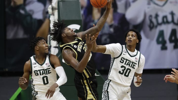 Dec 6, 2020; East Lansing, Michigan, USA; Western Michigan Broncos center Titus Wright (22) reaches for the ball against Michigan State Spartans forward Aaron Henry (0) and forward Marcus Bingham Jr. (30) during the first half at Jack Breslin Student Events Center. Mandatory Credit: Raj Mehta-USA TODAY Sports