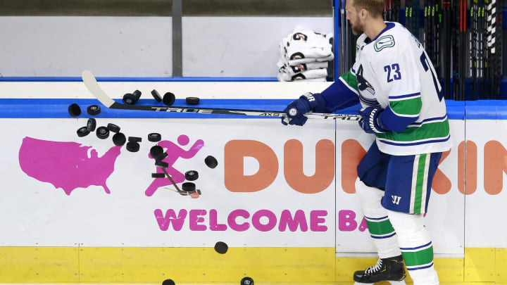 Alexander Edler #23 of the Vancouver Canucks knocks the puck onto the ice  (Photo by Jeff Vinnick/Getty Images)