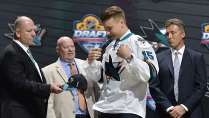 Jun 26, 2015; Sunrise, FL, USA; Timo Meier puts on a team jersey after being selected as the number nine overall pick to the San Jose Sharks in the first round of the 2015 NHL Draft at BB&T Center. Mandatory Credit: Steve Mitchell-USA TODAY Sports