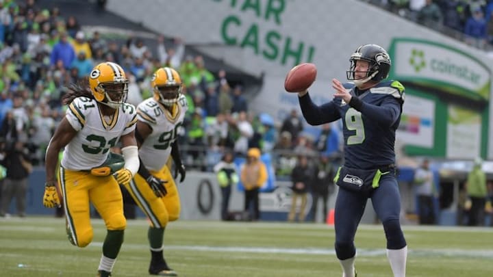 Jan 18, 2015; Seattle, WA, USA; Seattle Seahawks punter Jon Ryan (9) throws a 19 yard touchdown pass on a fake field goal past Green Bay Packers defensive end Datone Jones (95) and Davon House (31) during the third quarter in the NFC Championship Game at CenturyLink Field. Mandatory Credit: Kirby Lee-USA TODAY Sports