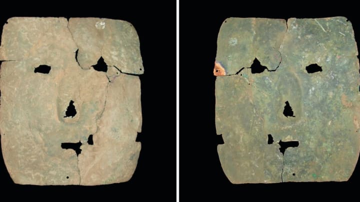 The front (left) and back (right) of a 3000-year-old copper mask. Small holes near the edges suggest the mask could have been attached with threads. Someone tried to repair the fracture near the left eye—note the holes near it.