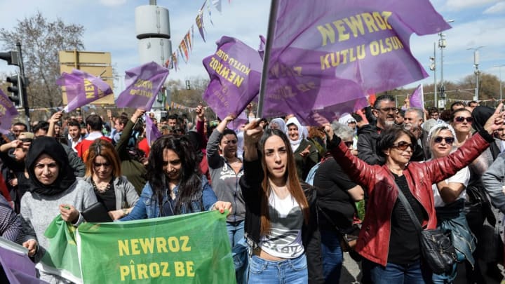 People wave flags as they celebrate the Persian festival of Newruz (also spelled Nowruz)