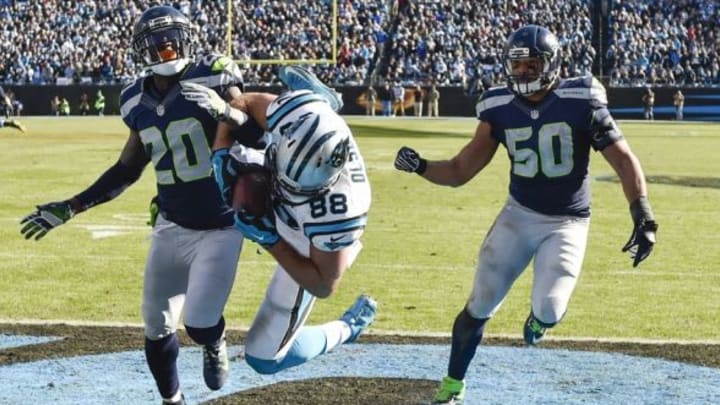 Jan 17, 2016; Charlotte, NC, USA; Carolina Panthers tight end Greg Olsen (88) scores a touchdown pas Seattle Seahawks cornerback Jeremy Lane (20) and outside linebacker K.J. Wright (50) during the second quarter in a NFC Divisional round playoff game at Bank of America Stadium. Mandatory Credit: John David Mercer-USA TODAY Sports