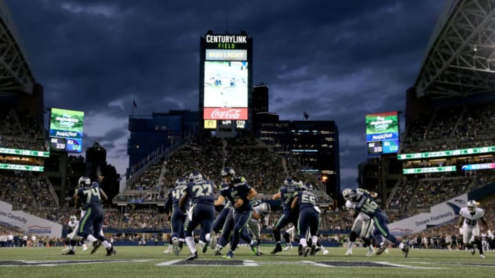 SEATTLE, WA - AUGUST 30: Austin Davis #6 hands the ball off to Mike Davis #27 of the Seattle Seahawks in the second quarter against the Oakland Raiders during their preseason game at CenturyLink Field on August 30, 2018 in Seattle, Washington. (Photo by Abbie Parr/Getty Images)