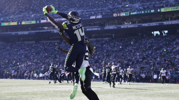 SEATTLE, WASHINGTON - OCTOBER 31: DK Metcalf #14 of the Seattle Seahawks catches the ball over Shaquill Griffin #26 of the Jacksonville Jaguars for a touchdown during the second quarter at Lumen Field on October 31, 2021 in Seattle, Washington. (Photo by Steph Chambers/Getty Images)