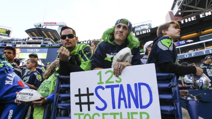 SEATTLE, WA - OCTOBER 01: A fan holds a '12s stand together' sign before the game between the Indianapolis Colts and the Seattle Seahawks at CenturyLink Field on October 1, 2017 in Seattle, Washington. (Photo by Jonathan Ferrey/Getty Images)